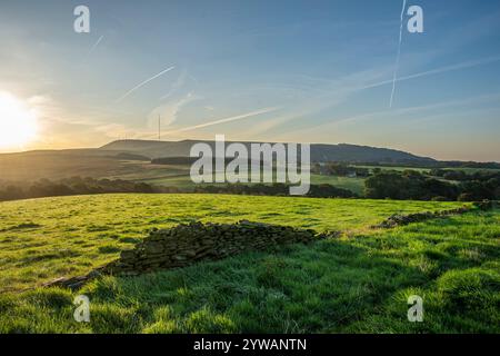 Sonnenaufgang am frühen Morgen von den Feldern über dem Blei Mine Valley Anglezarke mit Blick auf Rivington Pike und West Pennine Moors und Winter Hill dahinter Stockfoto