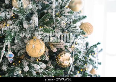 Geschmückter Weihnachtsbaum mit mattierten Zweigen, glitzernden Ornamenten und leuchtenden Lichtern isoliert auf weißem Hintergrund. Festliche Atmosphäre für Urlaub c Stockfoto