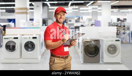 Der Manager eines Geräteschutzes schreibt ein Dokument vor den Waschmaschinen Stockfoto