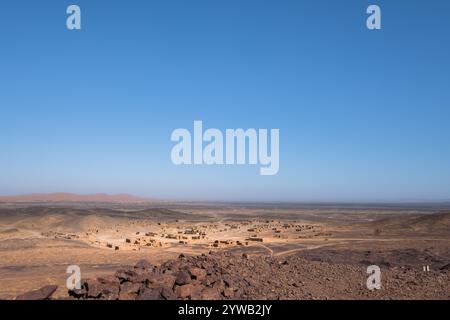 Panoramablick auf den alten Meeresboden der schwarzen Wüste von Marokko mit der Nähe der alten verlassenen Fossilienmine. Man sieht den alten verlassenen Schlammminen Stockfoto