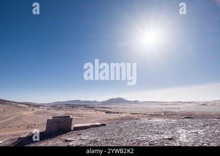 Panoramablick auf den alten Meeresboden der schwarzen Wüste von Marokko mit einer alten Schlammkonstruktion in der Nähe der alten verlassenen Fossilienmine. Stockfoto