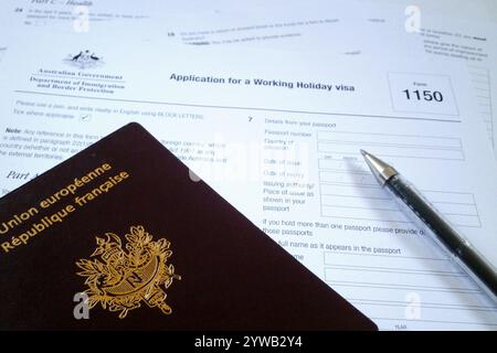 Ein Stift und ein französischer Reisepass auf einem WHV-Formular (Working Holiday Visa). Stockfoto