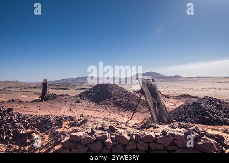 Panoramablick auf den alten Meeresboden der schwarzen Wüste von Marokko mit der Nähe der alten verlassenen Fossilienmine. Es gibt die Überreste einer Felsselec Stockfoto