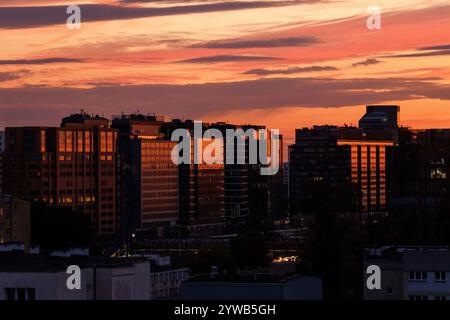 Ein lebendiger Sonnenuntergang, der leuchtende Farben über die weitläufige Skyline der Stadt wirft Stockfoto