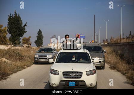 Homs, Syrien. Dezember 2024. Jubelnde Menschen auf den Straßen von Homs nach dem Fall der syrischen Stadt, um die Oppositionskräfte zu rebellieren. Die islamische Gruppe von Hayat Tahrir al-Sham und alliierte syrische Oppositionsgruppen erklärten am Samstag Nachmittag des 7. Dezember ihre Eroberung von Homs, der drittgrößten syrischen Stadt. Die Rebellengruppen begannen ihre militärische Kampagne am 27. November aus dem Norden Syriens und eroberten schnell strategische Gebiete von den syrischen Regierungstruppen Stockfoto