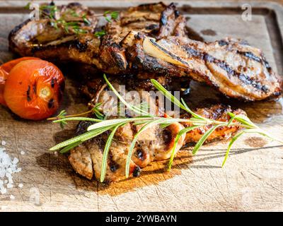 Gegrillter Lammsattel aus nächster Nähe auf hölzernem Schneidebrett Stockfoto