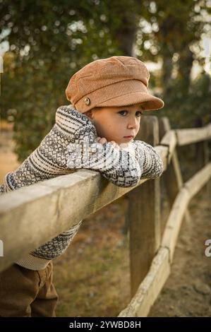 Junge auf dem Land beobachten Feinde und Reiter auf einer Farm Stockfoto