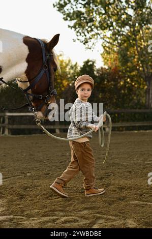 Junge auf dem Land beobachten Feinde und Reiter auf einer Farm Stockfoto