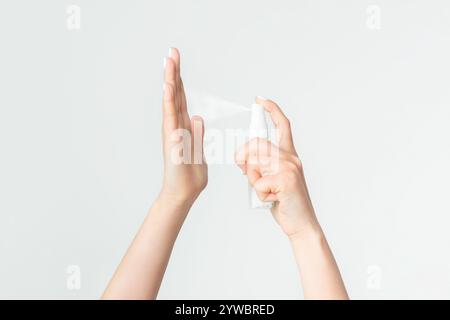 Nahaufnahme Ansicht der jungen Frau, die Antiseptikum auf ihre Hände vor weißem Hintergrund, Kopie Raum Stockfoto