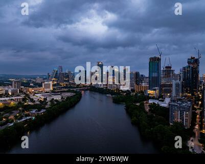 Die Skyline von Austin, Texas, erstrahlt auf dem Colorado River und bietet einen atemberaubenden Blick, wenn die Nacht unter einem dramatischen, wolkengefüllten Himmel fällt Stockfoto