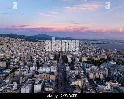 Luftaufnahme des Stadtzentrums von Thessaloniki bei Sonnenuntergang mit lebhaften Wolken über belebten Straßen und hohen Gebäuden mit Blick auf den Thermaischen Golf in Griechenland Stockfoto