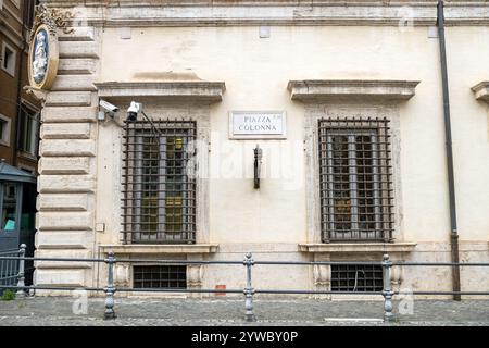 Fassade des Palazzo Chigi mit Gitterfenstern und einer Tafel zur Piazza Colonna in Rom, Italien Stockfoto