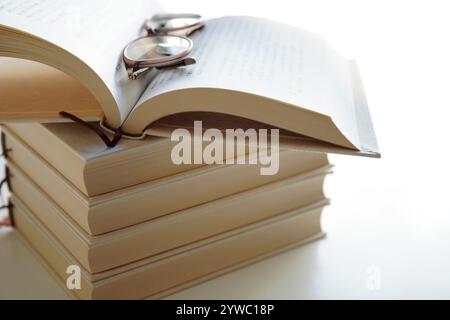 Öffne leeres Buch auf Stapeln von Büchern, Mock Up Stockfoto