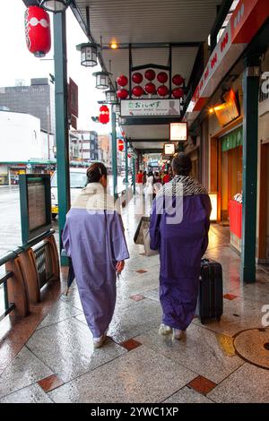 Ältere japanische Frauen tragen Kimonos im Regen auf der Shijo-dori-Straße in Gion, Kyoto, Japan Stockfoto