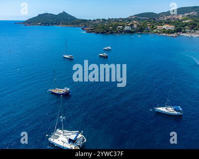 Panoramablick von oben auf das blaue Mittelmeer dea, Sandstrand der Stadt Agay, Sommerferienziel in der Nähe der roten Berge von Esterel, französische Riviera, Stockfoto