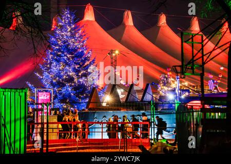 Tollwood Winterfestival auf der Theresienwiese, Weihnachtsbaum und Zelte sind in farbiges Licht getaucht, München, Dezember 2024 Deutschland, München, Dezember 2024, Tollwood Winterfestival, das Festivalgelände mit Zelten und Weihnachtsbaum ist in farbiges Licht getaucht, Dienstagabend um 18 Uhr, Theresienwiese, Winter, Kultur, Weihnachtszeit, Veranstaltung, *** Tollwood Winter Festival auf der Theresienwiese, Tannenbaum und Zelte sind in farbigem Licht getaucht, München, Dezember 2024 Deutschland, München, Dezember 2024, Tollwood Winter Festival, der Festivalbereich mit Zelten und Weihnachtsbaum ist BA Stockfoto