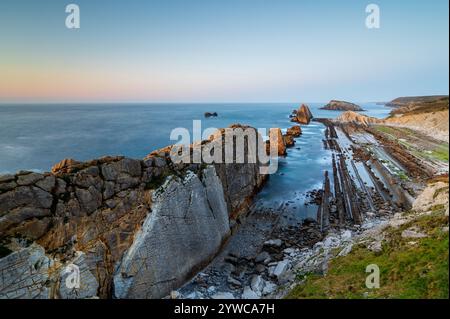 Dramatischer Blick auf Playa de la Arnia, Kantabrien, Spanien. Arnia Beach, Asturien bei Sonnenuntergang. Fantastische Landschaft, Linien, abstrakte Formen, schöne Farben. Stockfoto