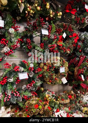 Kiew, Ukraine - 02. Dezember 2024: Eine Ausstellung von schönen Weihnachtskränzen mit roten Beeren, Tannenzapfen und dekorativem Grün. Stockfoto