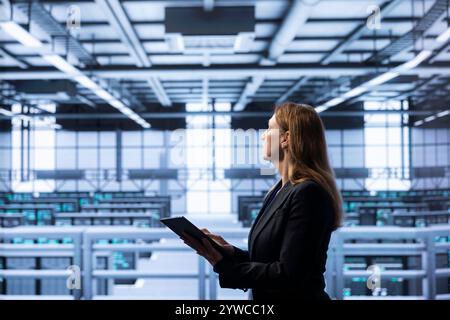 Mitarbeiter mit Fachkenntnissen in den Bereichen Serverwartung, Disaster Recovery-Planung und Durchsetzung von Sicherheitsprotokollen, die im Rechenzentrum arbeiten, um Ausfallzeiten zu reduzieren und die Geschäftskontinuität zu gewährleisten Stockfoto