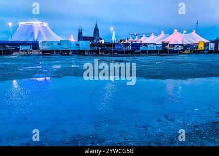 Tollwood Winterfestival auf der Theresienwiese, München, Dezember 2024 Deutschland, München, Dezember 2024, Tollwood Winterfestival, die Theresienwiese mit Zelten und Paulskirche spiegelt sich im Wasser der Pfützen, nach den Regentagen haben sich Wasserpfützen gebildet, Dämmerung, Blaue Stunde, das Winter-Tollwood geht vom 26. November bis 22. November. Dezember 2024, Winter, Kultur, Weihnachtszeit, Veranstaltung, *** Tollwood Winterfestival auf der Theresienwiese, München, Dezember 2024 Deutschland, München, Dezember 2024, Tollwood Winterfestival, die Theresienwiese mit Zelten und der St. Pauls Kirche ist reflektiert Stockfoto