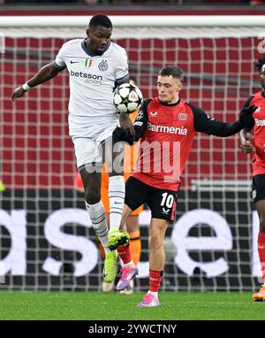 Leverkusen, Deutschland. Dezember 2024. Florian Wirtz (R) von Bayer 04 Leverkusen streitet mit Marcus Thuram von Inter Mailand während des UEFA Champions League-Spiels zwischen Bayer 04 Leverkusen und Inter Mailand am 10. Dezember 2024 in Leverkusen. Quelle: Ulrich Hufnagel/Xinhua/Alamy Live News Stockfoto