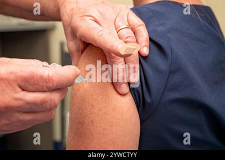 Frau, die eine Impfung von der Krankenschwester erhält, Nadelimpfung, australische Allgemeinpraxis, ärztliche Klinik des Hausarztes, Influenza covid infektio Stockfoto