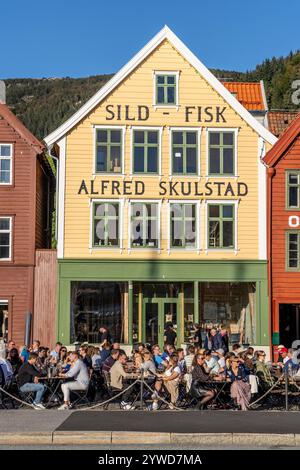 Bryggen, UNESCO-Weltkulturerbe im Stadtzentrum von Bergen, mit Bars und Pubs, in denen sich Freunde außerhalb des Hotels treffen, Bergen, Norwegen, Europa, 2024 Stockfoto