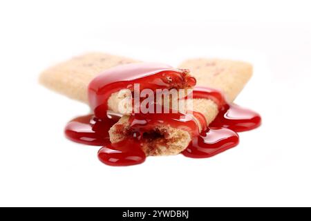 Streamen Sie rote Sirop auf Keksstäbchen. Weißer Hintergrund. Stockfoto