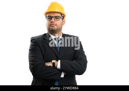 Porträt eines männlichen Bauunternehmers oder Architekten in elegantem Freizeitanzug und gelbem Schutzhelm mit überkreuzten Armen isoliert auf weißem Hintergrund Stockfoto