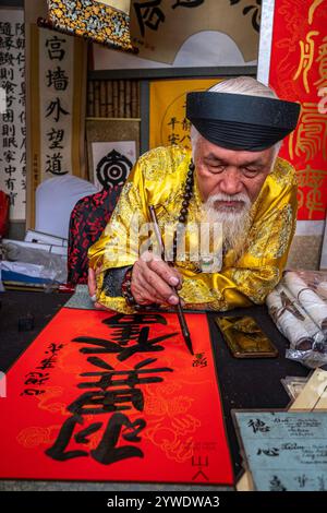 Vietnam, Hanoi, 14.02.2024, Tet-Festival, Chinesisches Neujahr, Alter Mann mit weißem Bart, Kalligraphie, Kalligraphe, Tempel der Literatur, traditionelles Gerinnsel Stockfoto