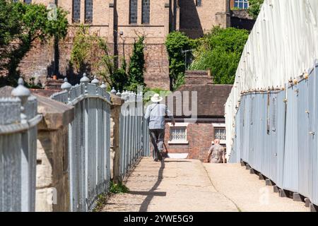 Ironbridge, Shropshire, Großbritannien, 22-06-2018. An einem heißen, sonnigen Juni-Tag schlendert ein Tourist über die berühmte Brücke. Das Wahrzeichen wird renoviert. Stockfoto