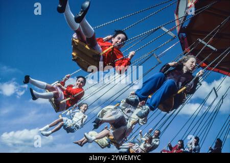 Zwillingsmädchen auf traditionellem Schaukelstuhl-Karussell, 1984. Blackheath, London, Großbritannien. Stockfoto