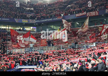 Gelsenkirchen, Deutschland. Dezember 2024. UEFA Champions League - Schachtar Donezk - FC Bayern München am 10.12.2024 in der Arena auf Schalke in Gelsenkirchen die mitgereisten Fans des FC Bayern München/München schwenken Fahnen und mit einer Schalparade Foto: Osnapix Credit: dpa/Alamy Live News Stockfoto