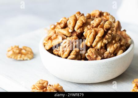 Reife und frische Walnusskerne in Schüssel oder Sackleinen ohne Schale auf rustikalem Tisch, gesunde Nussnahrung für Gehirn Stockfoto
