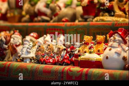 Ein lebhaftes Arrangement von Weihnachtsfiguren füllt die Regale und zeigt verschiedene Designs wie Weihnachtsmann, Schneemänner und verspielte Tiere. Diese Anzeige Stockfoto