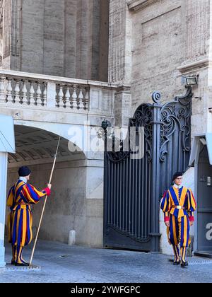 Vatikanstadt, Vatikan - 20. Juli 2022: Zwei Schweizergarden in traditioneller Uniform stehen an einem großen Eingang, in dem historische Architektur und Architektur zu sehen sind Stockfoto