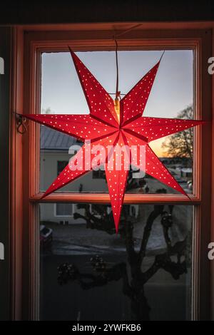 Elektrischer Adventsstern weihnachtsdekoration im Fenster mit Schnee draußen am Nachmittag in schweden Stockfoto