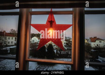Elektrischer Adventsstern weihnachtsdekoration im Fenster mit Schnee draußen am Nachmittag in schweden Stockfoto