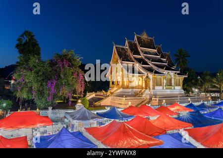 Nachtmarkt in Luang Prabang mit dem königlichen Palast von Luang Prabang, auch bekannt als Luang Prabang Nationalmuseum im Hintergrund, Laos Stockfoto