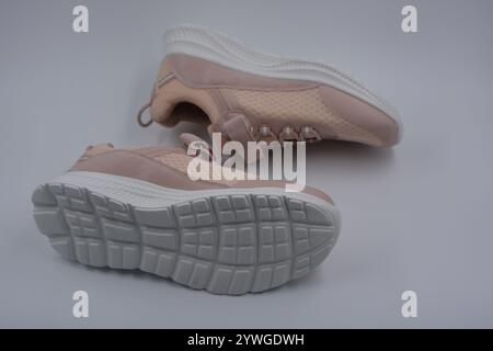 Weiche pfirsichfarbene Sportmokassins, weiche Sneakers aus synthetischem Mesh, Stoff, Kunstleder und weiße hohe Sohle. Stockfoto