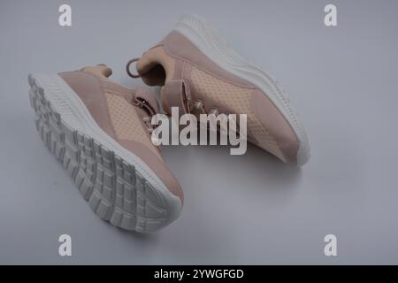 Weiche pfirsichfarbene Sportmokassins, weiche Sneakers aus synthetischem Mesh, Stoff, Kunstleder und weiße hohe Sohle. Stockfoto