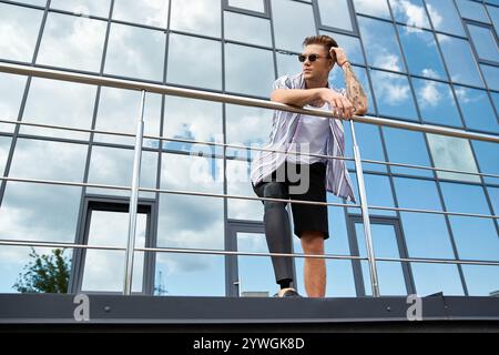 Ein junger Mann mit einer Beinprothese steht stilvoll vor einem modernen Gebäude unter blauem Himmel. Stockfoto