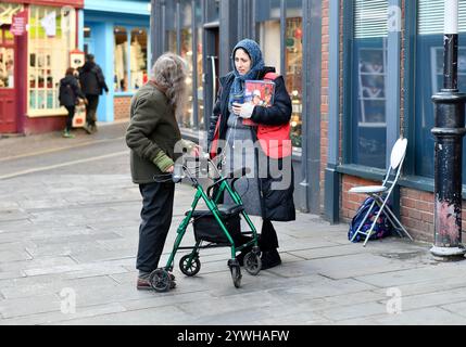 Ein örtlicher behinderter Bewohner, der mit einem Verkäufer mit großen Ausgaben in Ludlow, Shropshire, England, Großbritannien, chatten kann. Foto von Dave Bagnall. Stockfoto