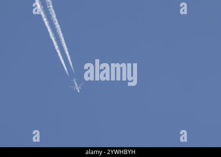 Airbus-Düsenflugzeuge fliegen in einem blauen Himmel mit einer Dampfspur oder einem Kondensstreifen dahinter, England, Großbritannien, Europa Stockfoto