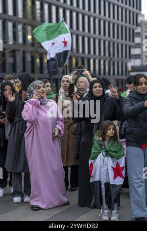 Syrische Frau feiert das Ende des Assad-Regimes nach dem Machtwechsel in Syrien bei einer Kundgebung auf dem Platz vor dem Hauptbahnhof in Stockfoto