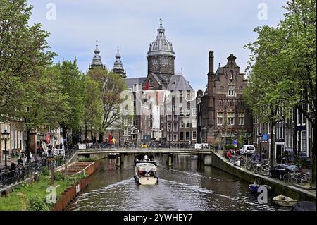 Blick von einer Brücke am Oudezijds Voorburgwal auf den Kanal und die Sint Nicolaaskerk, St. Nikolaus Kirche, Amsterdam, Nordholland, Niederlande Stockfoto