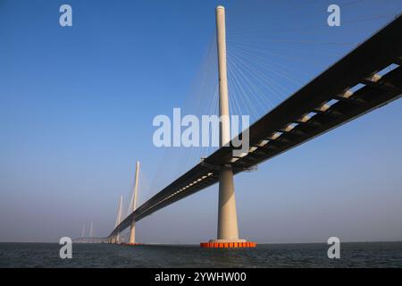 Zhuhai. Dezember 2024. Ein Drohnenfoto vom 7. Dezember 2024 zeigt einen Blick auf die Gaolan Port Bridge (mit zwei Haupttürmen auf der linken Seite) und die Huangmaohai Bridge (mit drei Haupttürmen auf der rechten Seite) in der südchinesischen Provinz Guangdong. Die Huangmaohai Cross-Sea Passage, die Guangdong Zhuhai City und Jiangmen City verbindet, wurde am Mittwoch offiziell für den Verkehr freigegeben. Diese Passage erstreckt sich über eine Gesamtlänge von etwa 31 Kilometern mit einem 14 km langen Abschnitt über dem Meer und umfasst zwei Hauptbrücken, nämlich die Huangmaohai Bridge und die Gaolan Port Bridge. Quelle: Liu Dawei/Xinhua/Alamy Live News Stockfoto