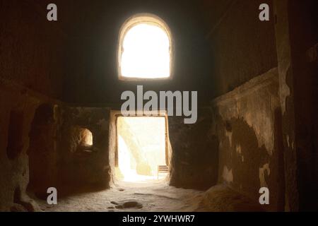 Dramatisches Sonnenlicht, das durch die natürliche Erosion von weichem vulkanischem Gestein ins Innere des Höhlenklosters eindringt Stockfoto