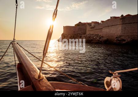 Altes Segelschiff segeln in den Sonnenuntergang neben der Stadtmauer von Dubrovnik Stockfoto