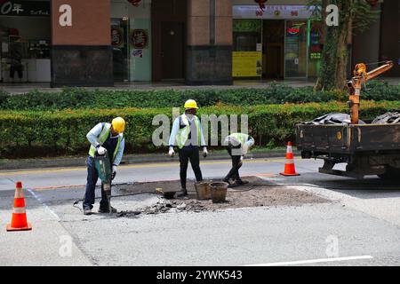 SINGAPUR CITY, SINGAPUR - 11. MÄRZ 2024: Straßenbauarbeiter bohren die Straßenoberfläche im Raum Rochor, Singapur City. Stockfoto